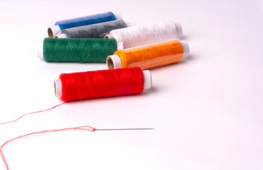 colorful sewing thread set and needle on white background