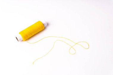 Beyaz arkaplanda sarı dikiş ipliği