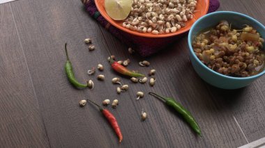 close up view of raw and prepared sprouted soy in bowls with towel, lemon and peppers, healthy food concept