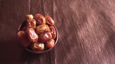 dried dates in bowl on the wooden table