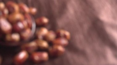 blurred footage of dried dates in bowl on the wooden table