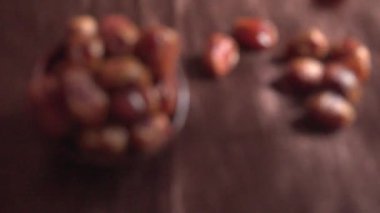 defocused footage of dried dates in bowl on the wooden table