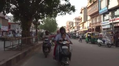 Sokak manzaralı triportöre binen Hintliler