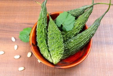 fresh green momordica charantia or bitter melon on wooden surface