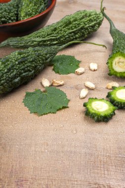 fresh green momordica charantia or bitter melon on wooden surface