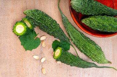 fresh green momordica charantia or bitter melon on wooden surface