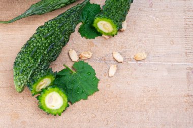 fresh green momordica charantia or bitter melon on wooden surface