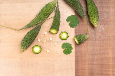 fresh green momordica charantia or bitter melon on wooden surface