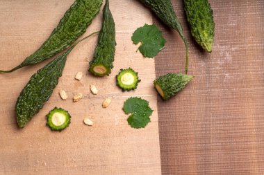 fresh green momordica charantia or bitter melon on wooden surface