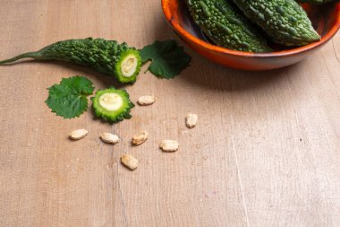 fresh green momordica charantia or bitter melon on wooden surface