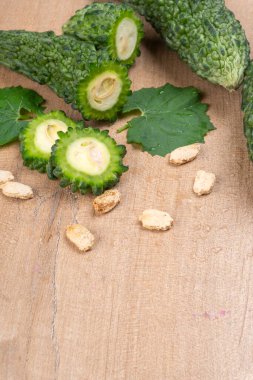 fresh green momordica charantia or bitter melon on wooden surface