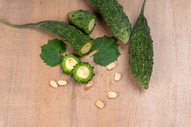 fresh green momordica charantia or bitter melon on wooden surface
