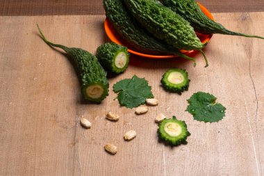 fresh green momordica charantia or bitter melon on wooden surface