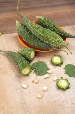 fresh green momordica charantia or bitter melon on wooden surface