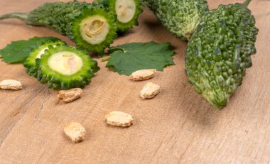 fresh green momordica charantia or bitter melon on wooden surface