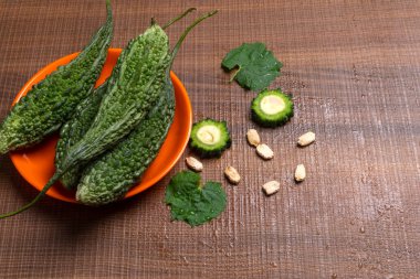 fresh green momordica charantia or bitter melon on wooden surface