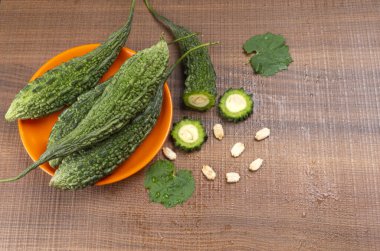 fresh green momordica charantia or bitter melon on wooden surface