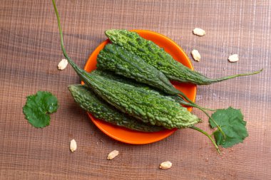 fresh green momordica charantia or bitter melon on wooden surface