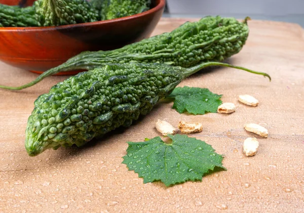 fresh green momordica charantia or bitter melon on wooden surface