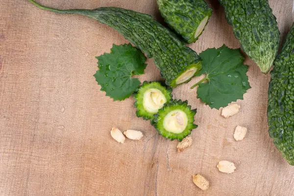 fresh green momordica charantia or bitter melon on wooden surface