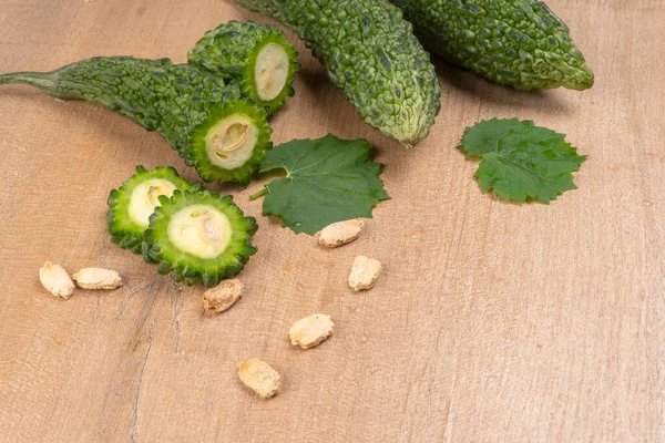 fresh green momordica charantia or bitter melon on wooden surface