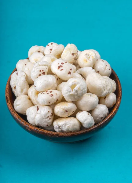 stock image Organic crispy lotus pops seeds or phool makhana in bowl on blue background