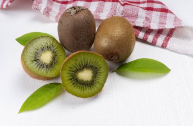 beyaz ahşap arka planda kivi meyvesi