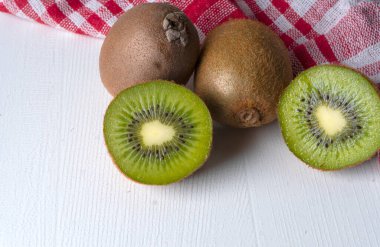 beyaz ahşap arka planda kivi meyvesi