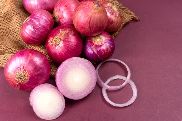 stock image fresh red onions with sackcloth, close up view