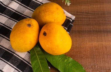 Tahta arka planda olgun sarı mango meyvesi