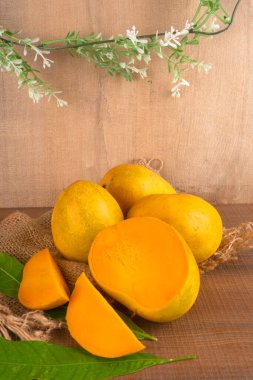 Tahta arka planda olgun sarı mango meyvesi
