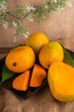 Tahta arka planda olgun sarı mango meyvesi