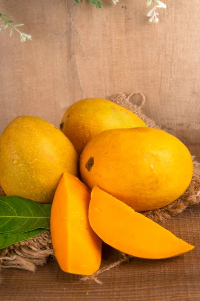 stock image ripe yellow mango fruit on wooden background