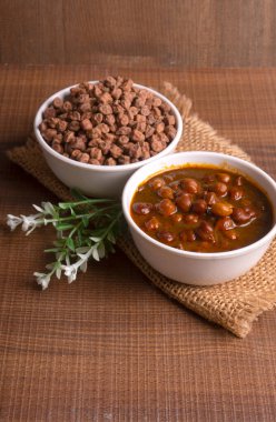 Masada bir kase nohut çorbası ve çiğ fasulye var.