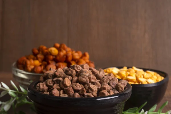 stock image bowl of chickpeas and dried corn on wooden background