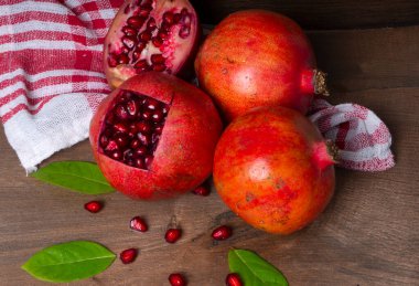 Ahşap zemin üzerinde tohumları olan nar meyveleri.