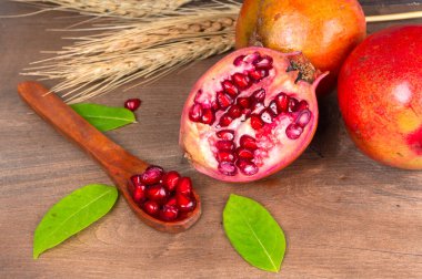 Ahşap zemin üzerinde tohumları olan nar meyveleri.