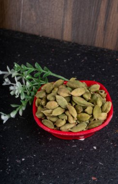 Kırmızı kasede aromatik yeşil kakule, yakın görüş.