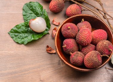 Tahta arka planda taze liçi meyveleri