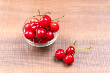 Tahta arka planda taze kırmızı kirazlar.