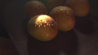 Olgun sarı mango meyvesi ve karanlıkta su damlaları.