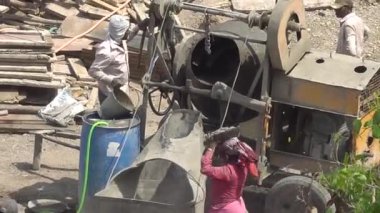 İnşaat alanında beton karıştırıcı ile çalışan insanlar