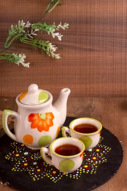 Hindistan masala çayı çaydanlık ve ahşap arka planda baharatlar.
