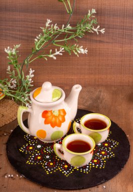 Hindistan masala çayı çaydanlık ve ahşap arka planda baharatlar.