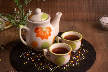Hindistan masala çayı çaydanlık ve ahşap arka planda baharatlar.
