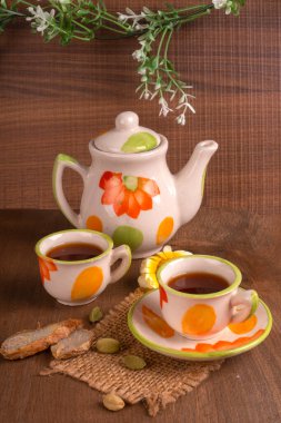 Hindistan masala çayı çaydanlık ve ahşap arka planda baharatlar.