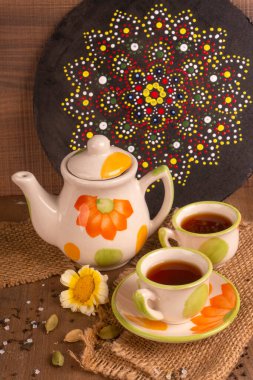 Hindistan masala çayı çaydanlık ve ahşap arka planda baharatlar.
