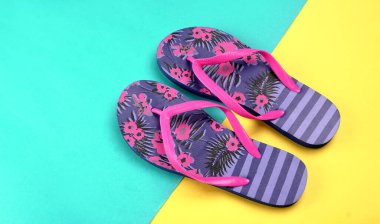 Turkuaz ve sarı arka planda parmak arası terlikler.