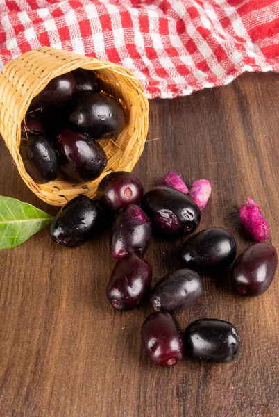 stock image fresh black olives with basket on wooden background