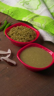 Kase dolusu yeşil bezelye ve ahşap zemin üzerinde ezilmiş makarna.